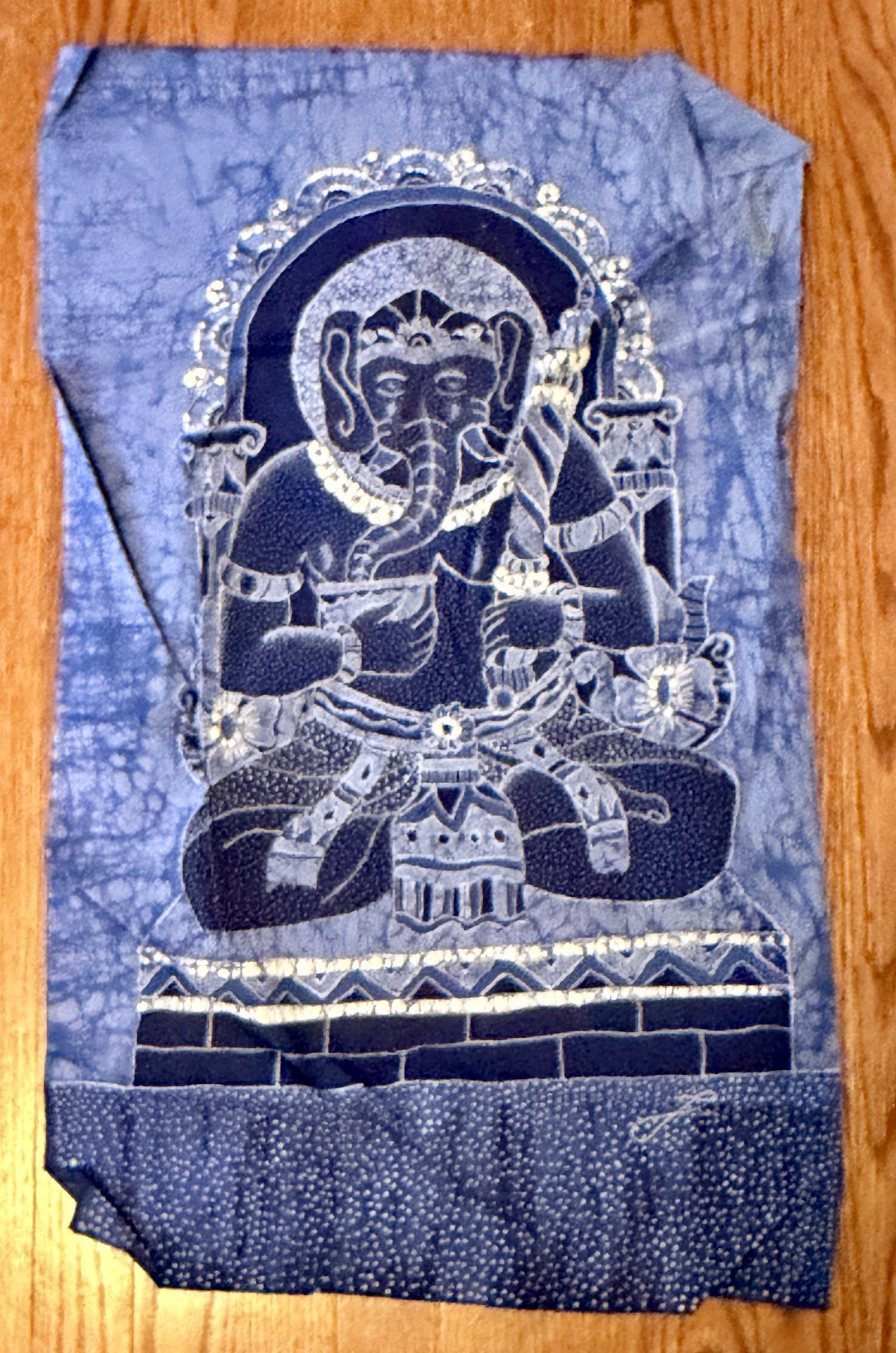 Batik indigo représentant Ganesh assis, quatre bras, sur un socle de briques