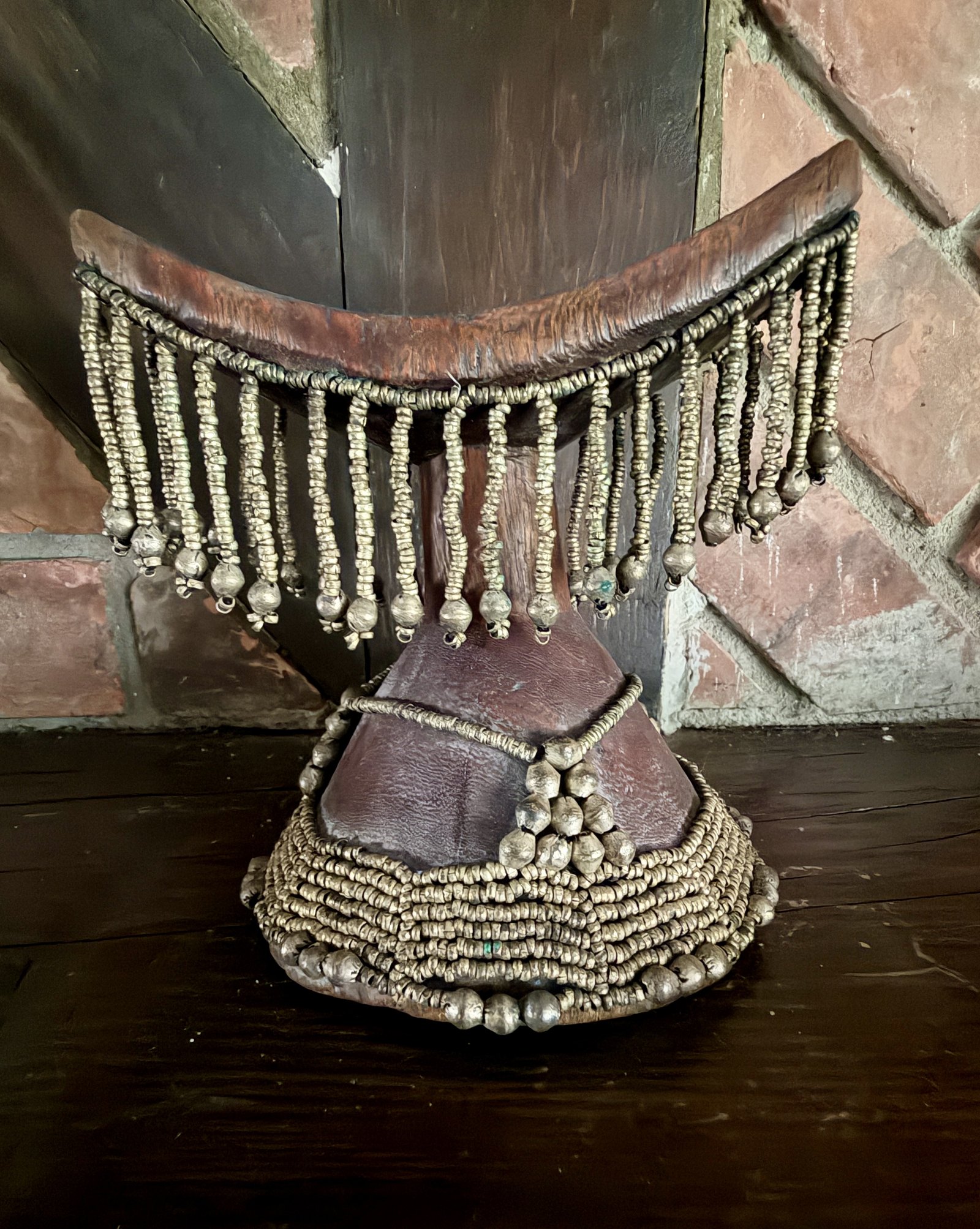 Coiffe africaine perlée à franges, présentée sur son socle