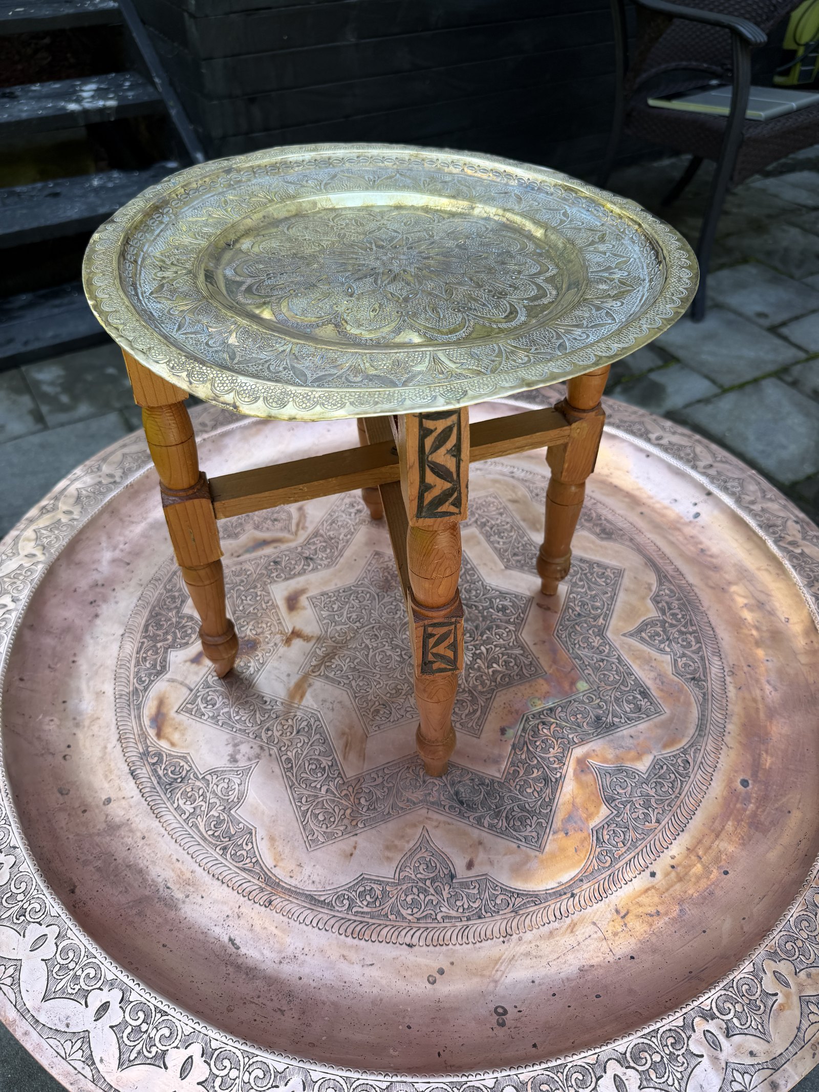 Petite table-plateau en laiton grave sur pietement pliant en bois clair, vue d'ensemble