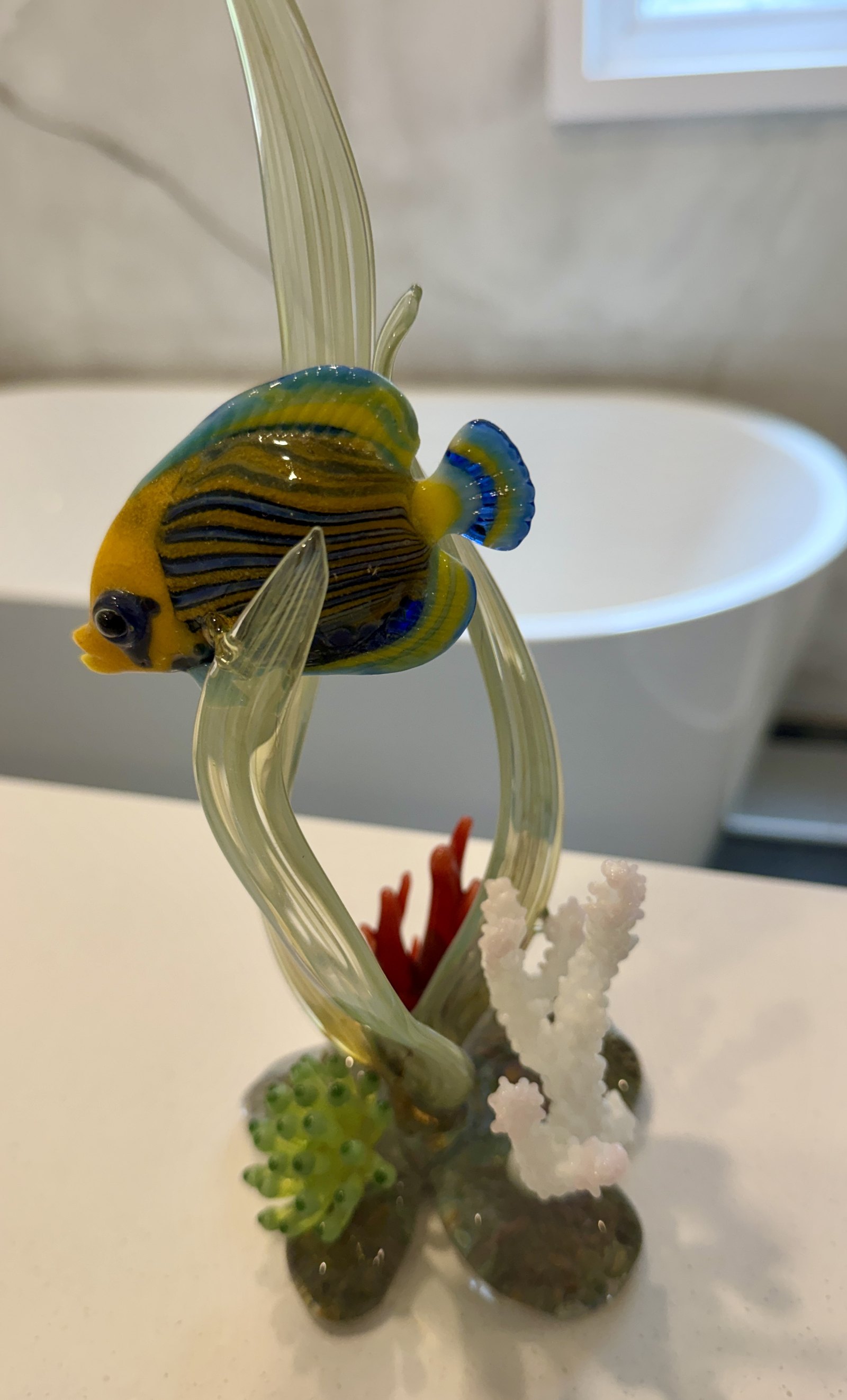 Poisson-ange en verre souffle, corps ambre raye, entre deux frondes d'algue de verre, sur socle de rocher