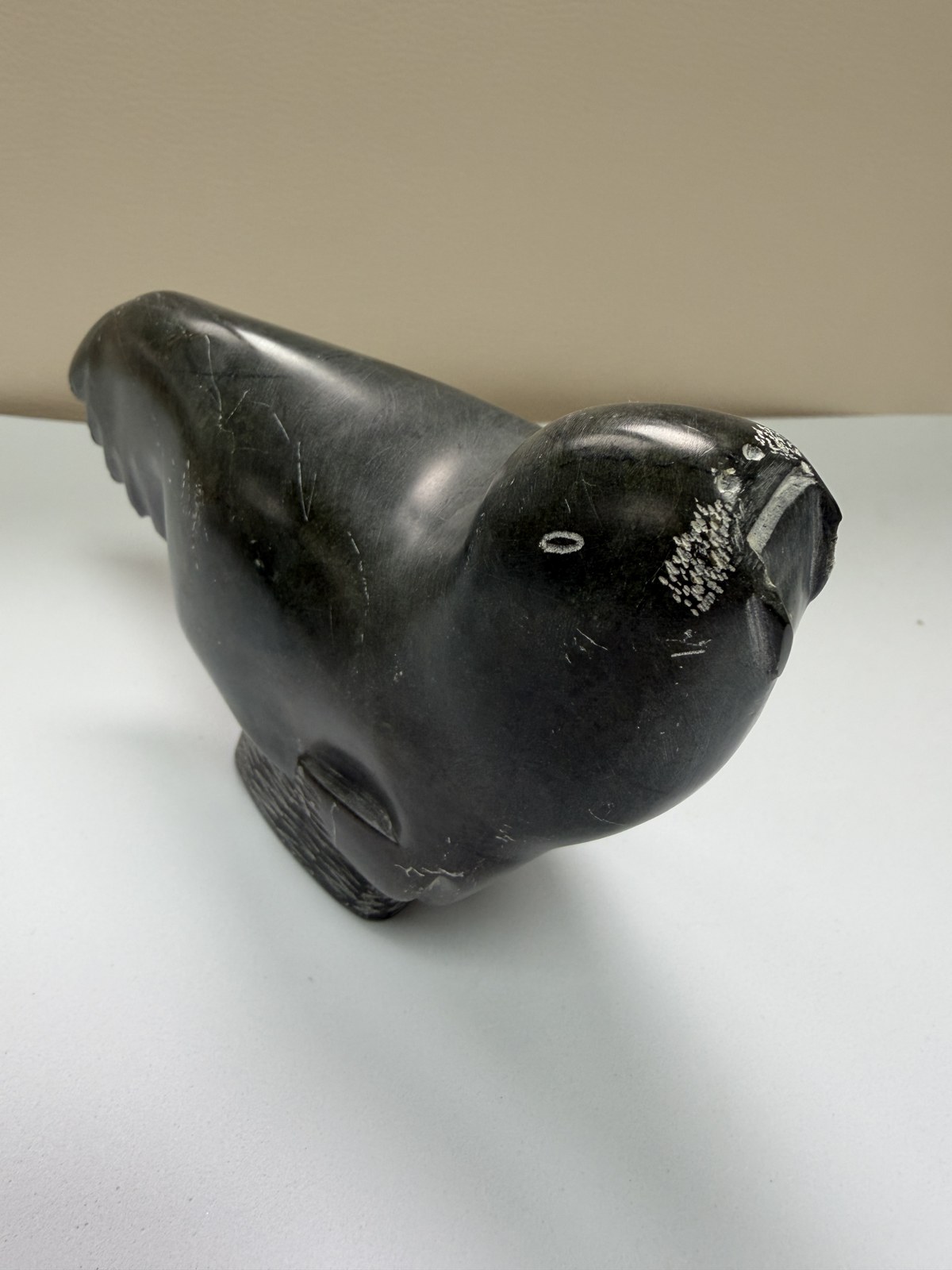 Sculpture inuite en pierre à savon sombre — phoque signé