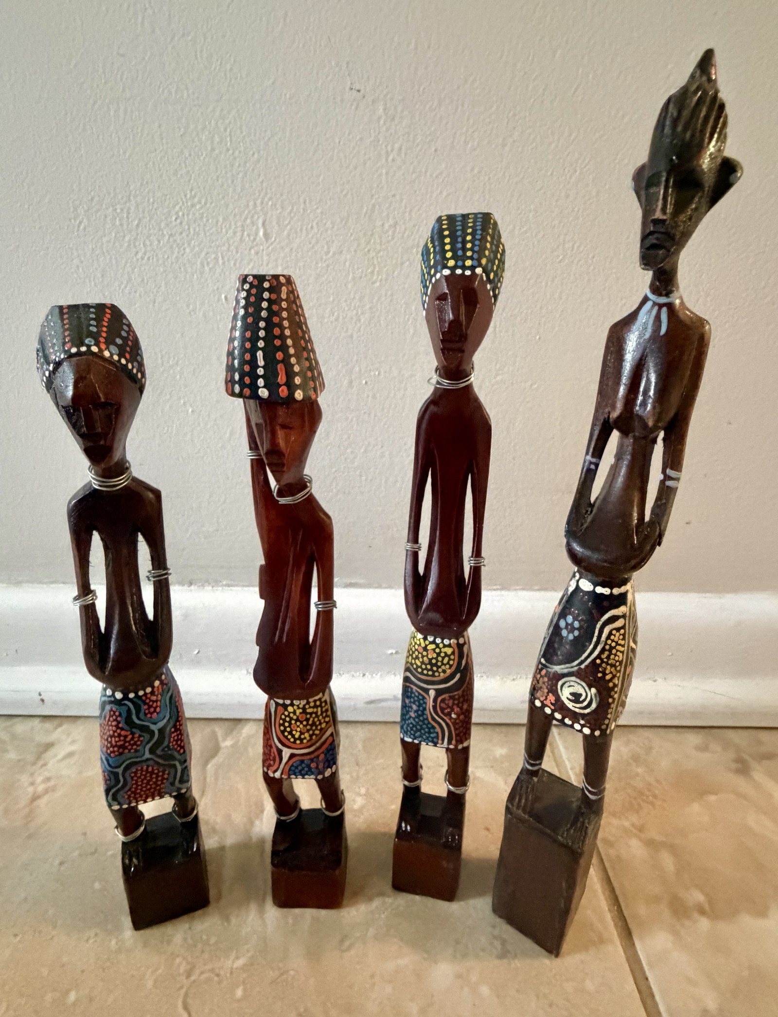 Quatre statuettes africaines en bois peint, alignées